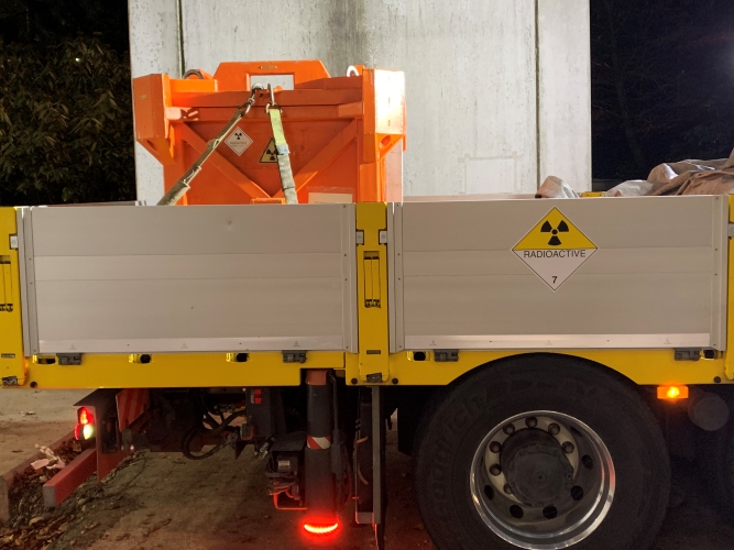 Gefahrenguttransporter mit der widerstandsfähigen Transportbox, in der der Quellenbehälter platziert wird.