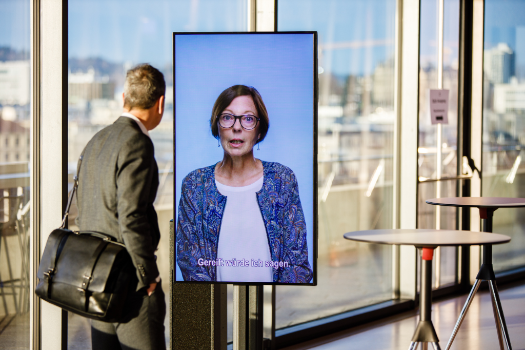 David Hess vor Porträts der Ausstellung 