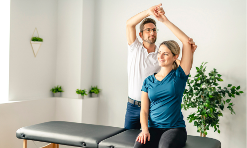 Un physiothérapeute fait un exercice avec une patiente